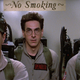 Stantz, Spengler, and Venkman stand in an elevator, waiting to bust ghosts while a sign above them reads "No Smoking.".